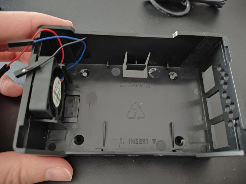 Photo of Raspberry Pi case with fan. Printed instructions read 1 Insert, 2 Snap
